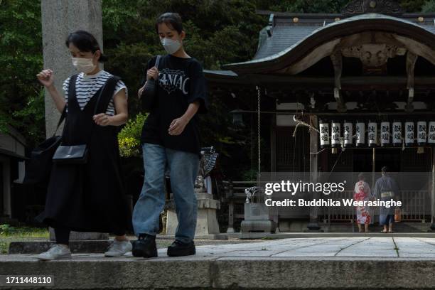 Young couple dressed in Yukata robes, pray at the Shinto shrine while they visit Kinosaki Hot Spring Resort Town on October 01, 2023 in Toyooka,...