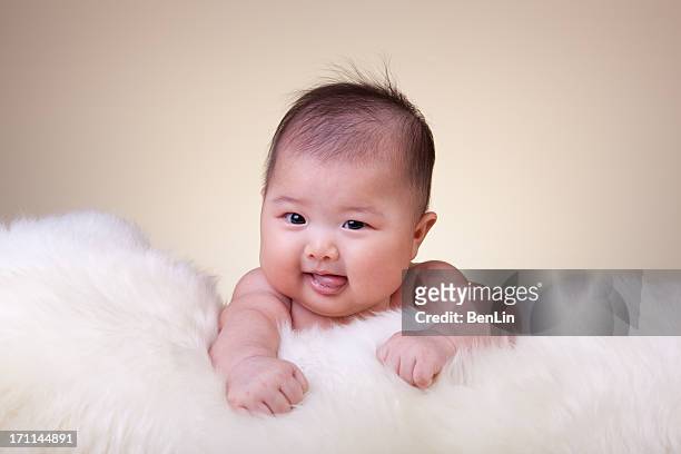 cute asian baby resting on sheepskin - sheepskin stock pictures, royalty-free photos & images