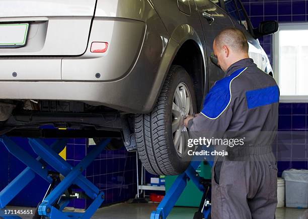 in auto repair shop....auto mechanic is changin tire - snow tire stock pictures, royalty-free photos & images