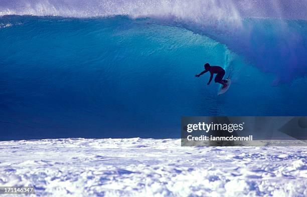 surfer on a blue wave - waimea bay stock pictures, royalty-free photos & images