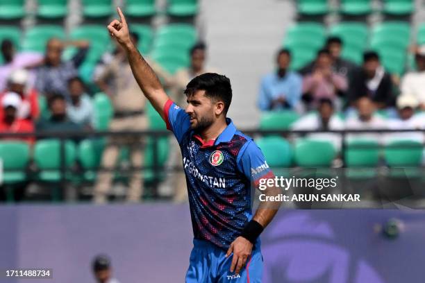 Afghanistan's Fazalhaq Farooqi celebrates after the dismissal of Bangladesh's Tanzid Hasan during the 2023 ICC Men's Cricket World Cup one-day...