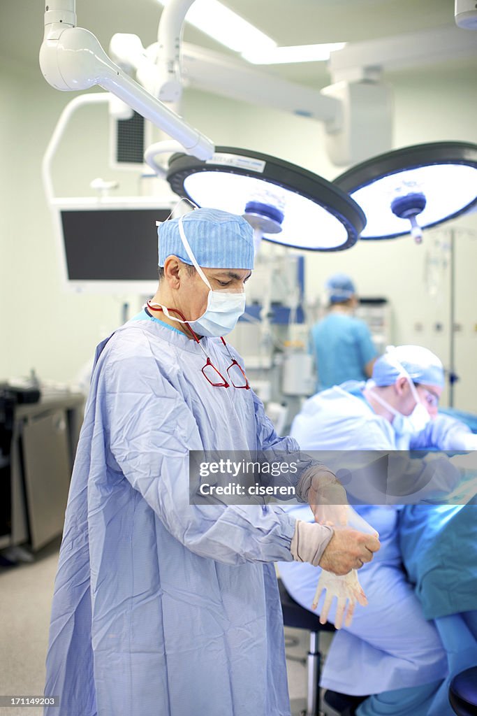 Doctor taking off gloves