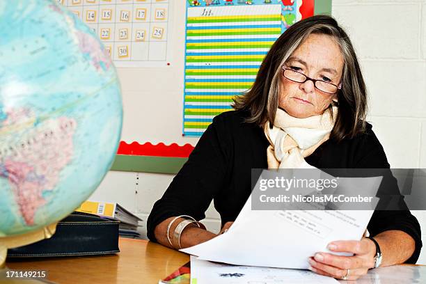 senior elementary teacher correcting homework - grading stock pictures, royalty-free photos & images