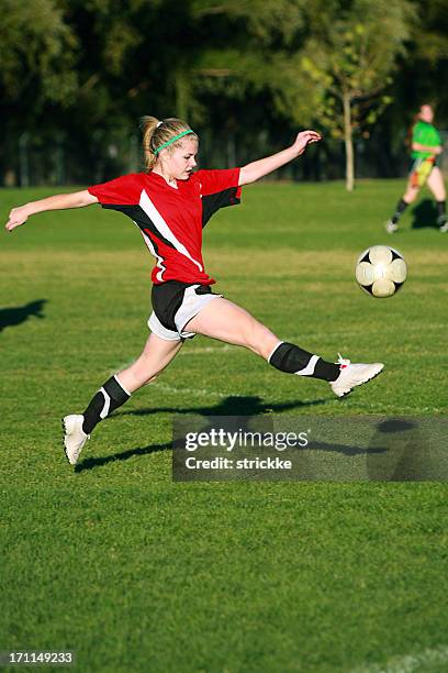 weibliche fußball fliegt in der luft schwebend'auf den ball - torschuss stock-fotos und bilder