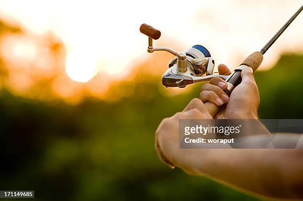 fisherman casting in soft focus. - fishing pole stock pictures, royalty-free photos & images