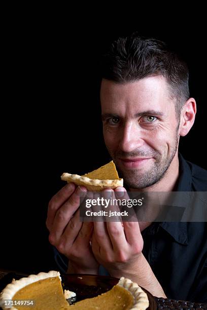 handsome man eating pumpkin pie - man eating pie stock pictures, royalty-free photos & images