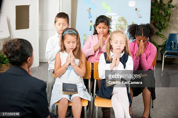 sunday school kids - child praying stock pictures, royalty-free photos & images