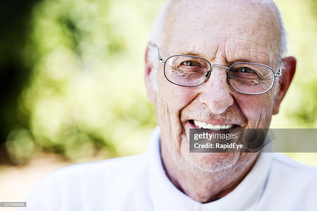 Charming old man smiles happily