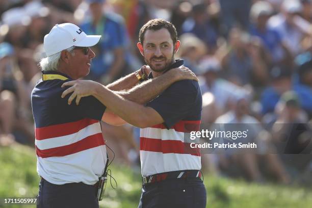 Patrick Cantlay of Team United States and Fred Couples, Vice Captain of Team United States celebrate on the 17th green during the Sunday singles...