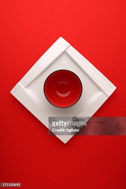 red circle bowl on white square plate - square plate stock pictures, royalty-free photos & images