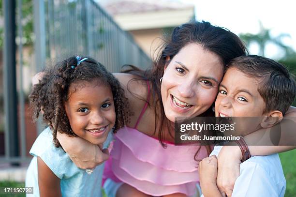 hispanic woman and two kids happily looking at the camera - puerto rican ethnicity stockfoto's en -beelden