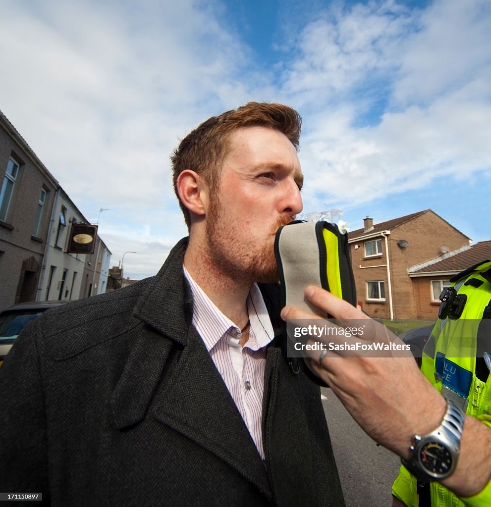 A police man giving a man an alcohol test