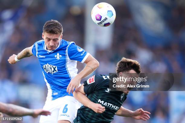 Marvin Mehlem of SV Darmstadt 98 jumps for the ball with Olivier Deman of Werder Bremen during the Bundesliga match between SV Darmstadt 98 and SV...