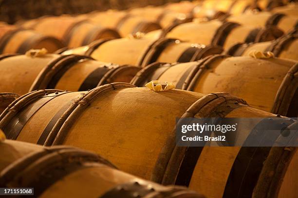 an old wine cellar full of barrels - barrel stockfoto's en -beelden