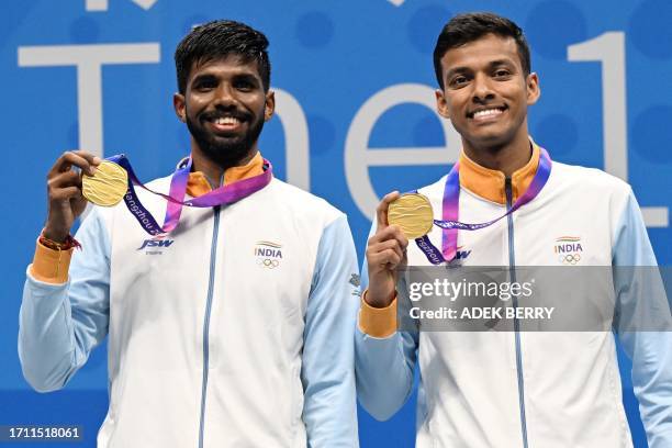Gold medallists India's Satwiksairaj Rankireddy and Chirag Shetty pose on the podium following the badminton men's doubles final match during the...