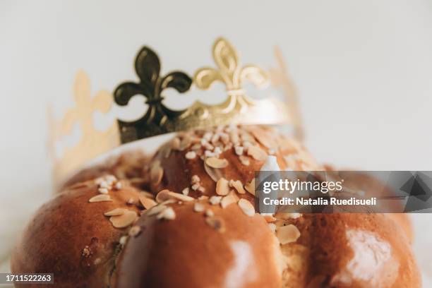 traditional epiphany bread known as dreikönigskuchen in switzerland with golden crown and a king. - dreikönigsfest foto e immagini stock