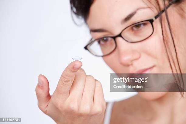 a lady staring at a contact lens - contact lens stock pictures, royalty-free photos & images