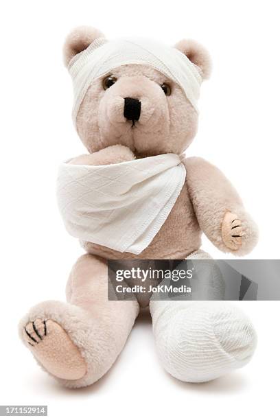 beige teddy bear wrapped in bandages and a cast - bandage stockfoto's en -beelden