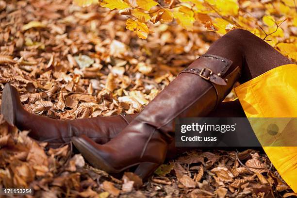 model auf bunten herbstblätter - hohe stiefel stock-fotos und bilder