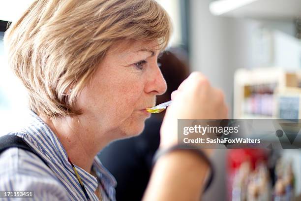 frau verkostung olivenöl - flavoring stock-fotos und bilder