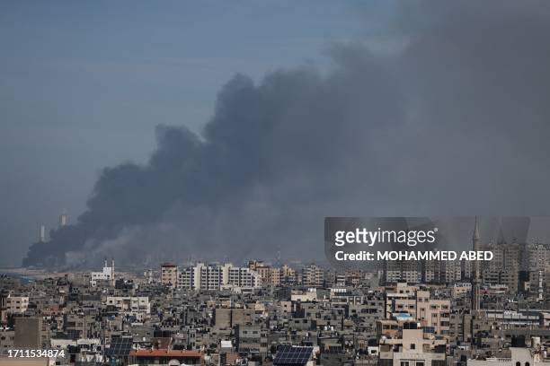 Graphic content / TOPSHOT - Smoke billows over the Israeli side of the border with Gaza as seen from Gaza City on October 7, 2023 following a series...