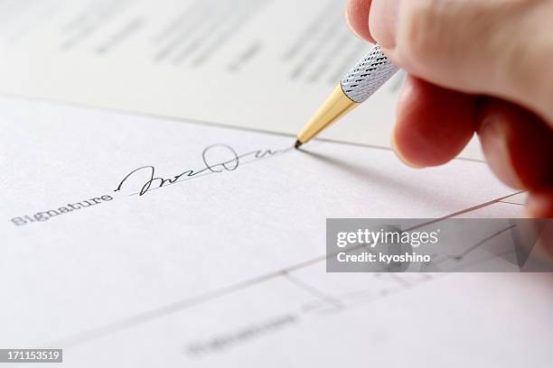 close-up of signing a contract with shallow depth of field - ondertekenen stockfoto's en -beelden