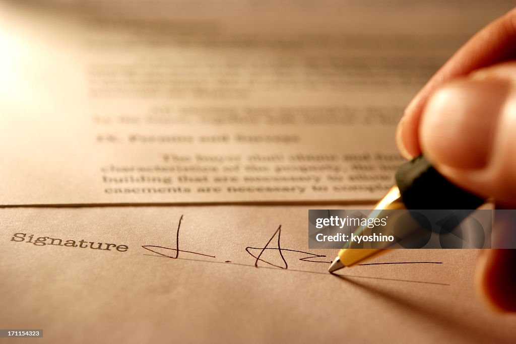 Sepia toned Image of signing a contract with light rays