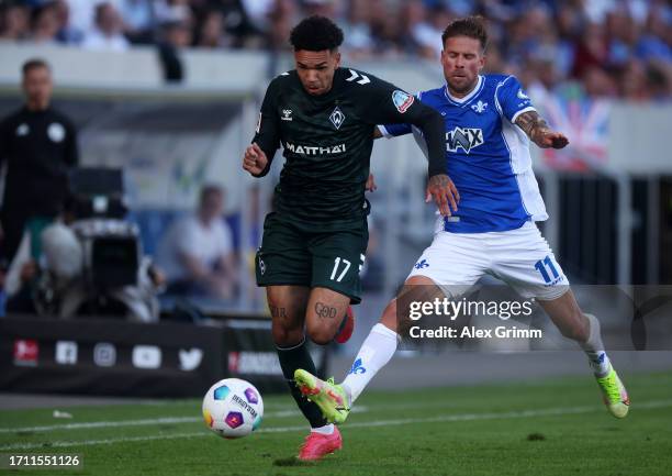 Justin Njinmah of Werder Bremen is challenged by Tobias Kempe of SV Darmstadt 98 during the Bundesliga match between SV Darmstadt 98 and SV Werder...