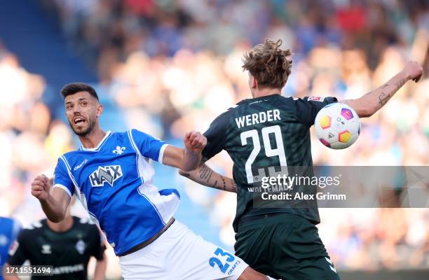 Klaus Gjasula of SV Darmstadt 98 clashes with Nick Woltemade of Werder Bremen during the Bundesliga match between SV Darmstadt 98 and SV Werder...