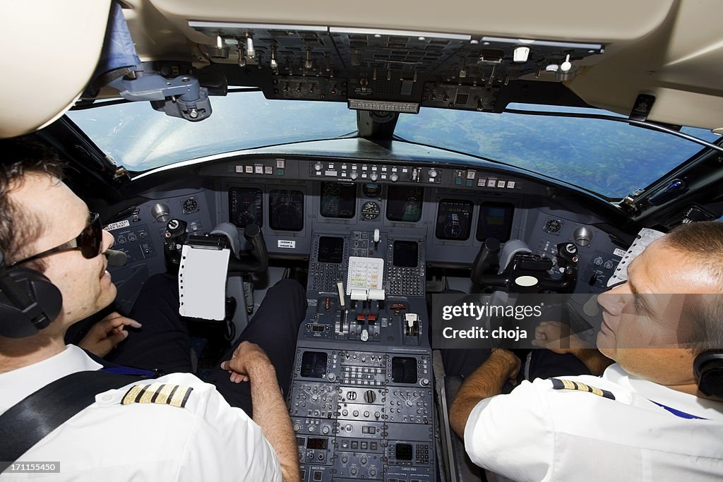 Coppia di giovani Piloti nella cabina di pilotaggio, avvicinarsi all'aeroporto