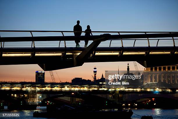 silhouettes of two lovers on millennium bridge at twilight, london - london dusk stock pictures, royalty-free photos & images
