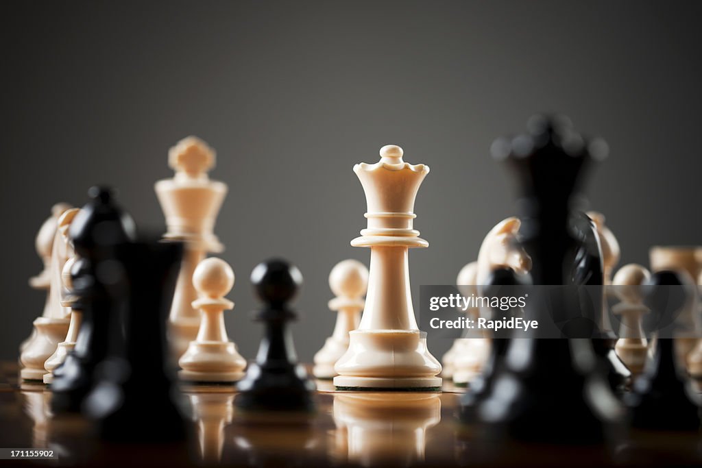 Chessboard level view of game, the white queen menacingly central
