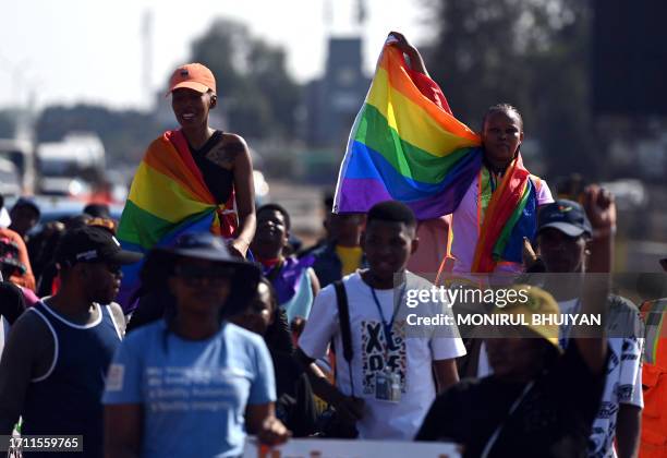 People hold placards and rainbow flags while taking part in the annual Gaborone Pride march in Gaborone on October 7, 2023.