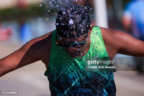 Volunteer pours water on to an athlete 3during IRONMAN 70.3 Barcelona on October 01, 2023 in Calella, Spain.