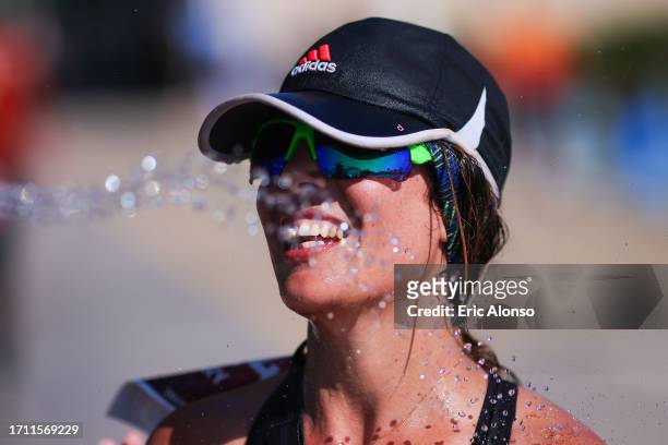 Volunteer pours water on to an athlete 3during IRONMAN 70.3 Barcelona on October 01, 2023 in Calella, Spain.