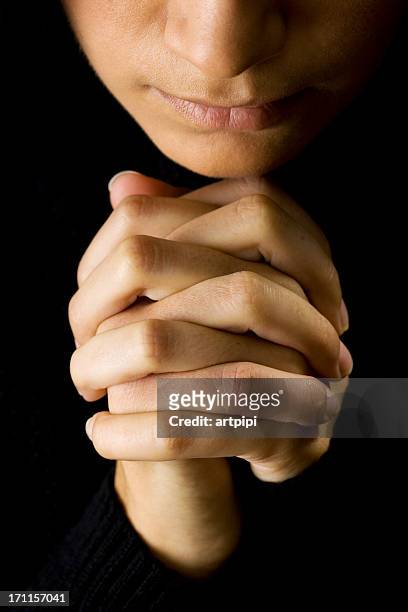 woman praying with hands closed in the dark - patience please stock pictures, royalty-free photos & images