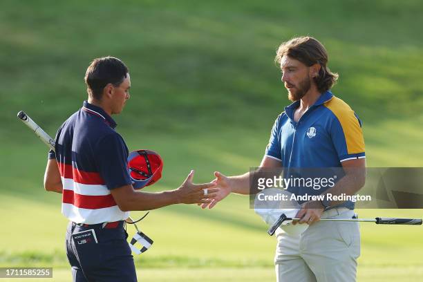 Tommy Fleetwood of Team Europe and Rickie Fowler of Team United States shake hands on the 17th green following their match during the Sunday singles...