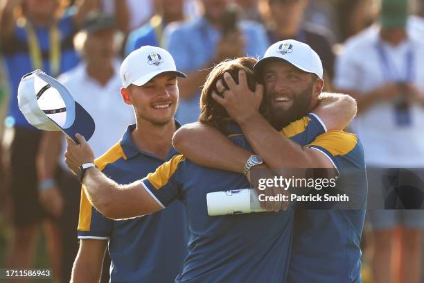 Tommy Fleetwood of Team Europe celebrates winning his match against Rickie Fowler of Team United States with teammates Jon Rahm and Nicolai Hojgaard...