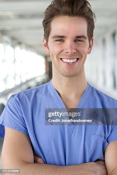 smiling man in blue scrubs - hospital orderly stock pictures, royalty-free photos & images