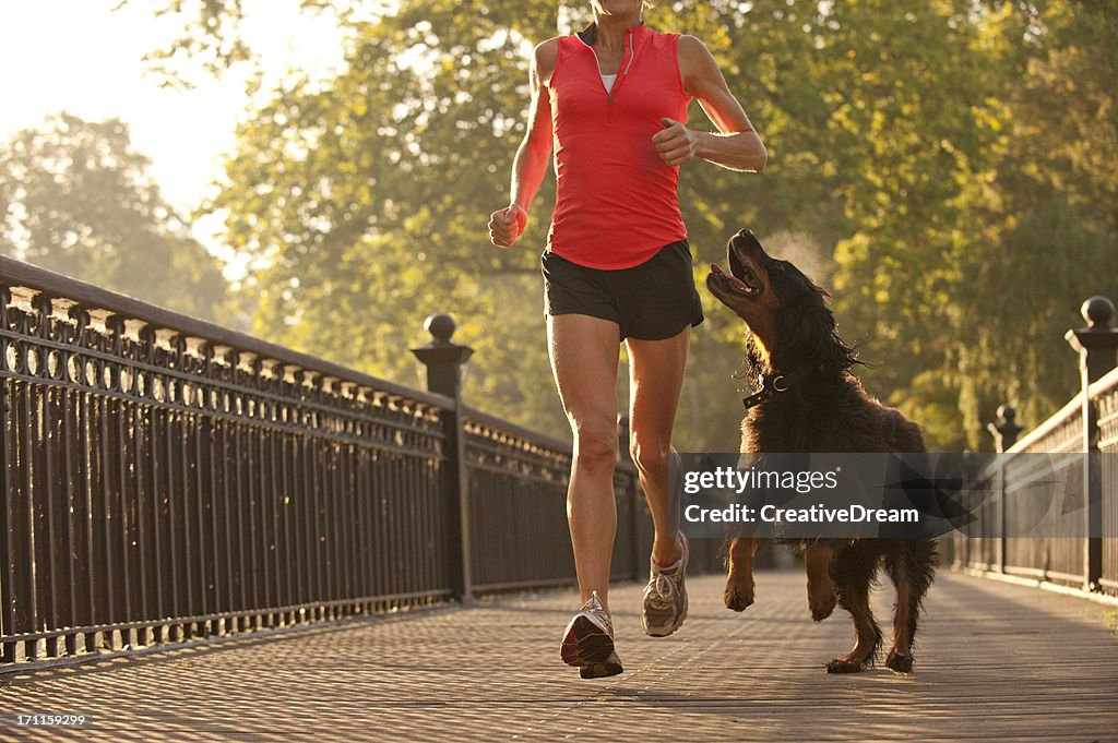 Frau läuft im park mit Hund