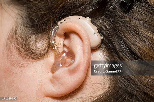 close up of woman wearing digital hearing aid - ear close up women stockfoto's en -beelden