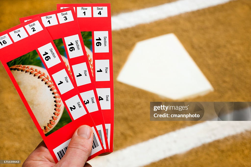 Hand holding Baseball Tickets at home plate