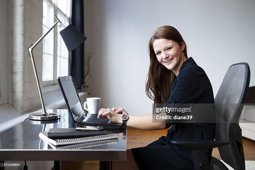 Happy young businesswoman in an office