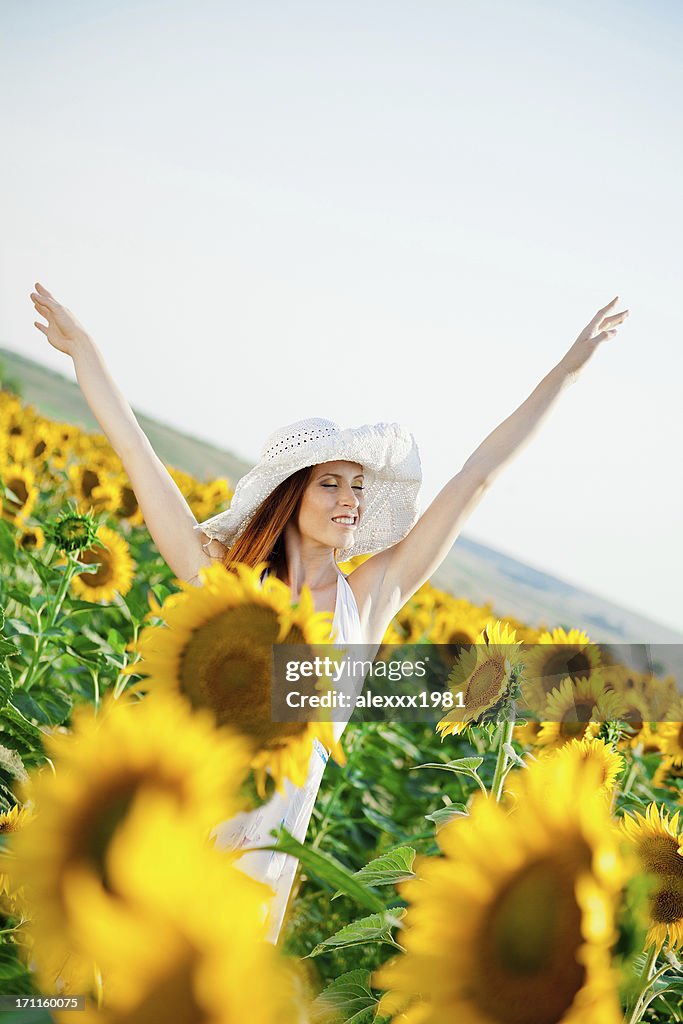 Young woman relaxing among sunflowers