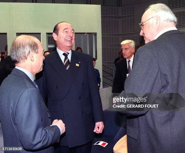 Greek Prime Minister Constantinos Simitis observes a light hearted exchange between French President Jacques Chirac and Germany's Chancellor Helmut...