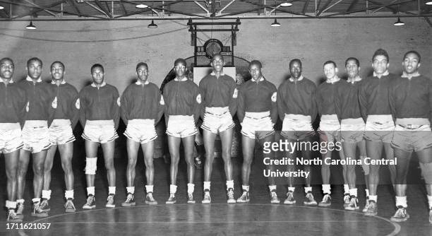 Group photograph of North Carolina College Men Basketball Team standing on the court.