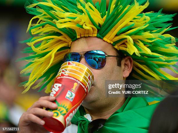 Spectators drinks beer as he waits for the start of the FIFA Confederations Cup Brazil 2013 Group A football match between Japan and Mexico, at the...