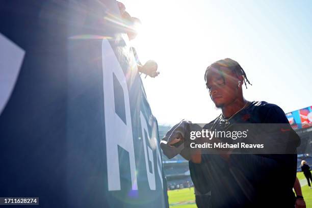 Justin Fields of the Chicago Bears signs autographs prior to a game against the Denver Broncos at Soldier Field on October 01, 2023 in Chicago,...