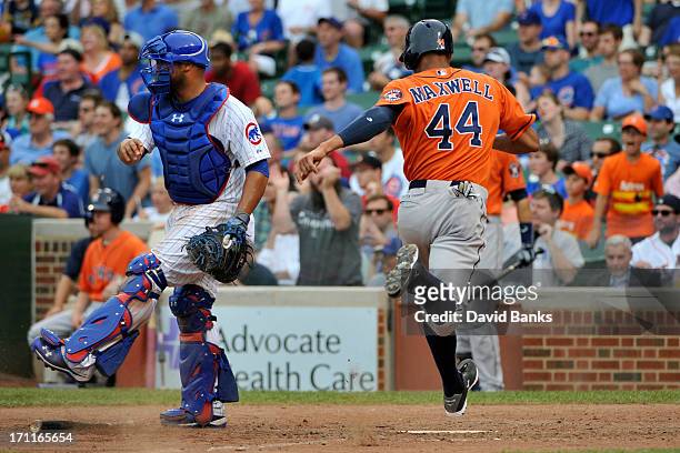 Justin Maxwell of the Houston Astros scores the go-ahead run as Welington Castillo of the Chicago Cubs looks on during the ninth inning on June 22,...