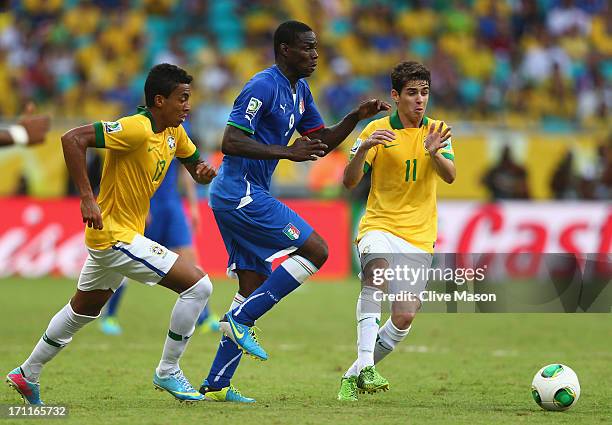 Mario Balotelli of Italy competes with Oscar and Luiz Gustavo of Brazil during the FIFA Confederations Cup Brazil 2013 Group A match between Italy...